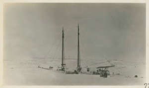 Image of Bowdoin in winter quarters with full moon over horizon